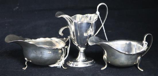 Two silver sauce boats and a silver helmet-shaped cream jug